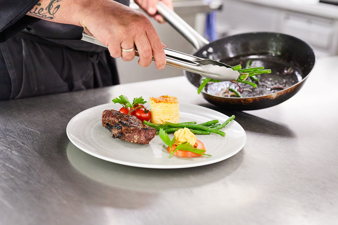 Close-up of a plate being prepared in the kitchen.